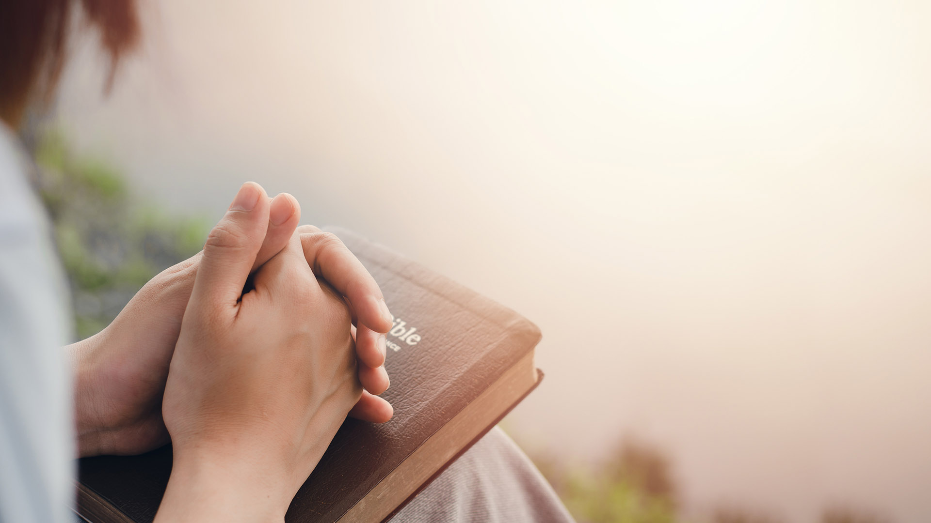 Woman praying holding Bible