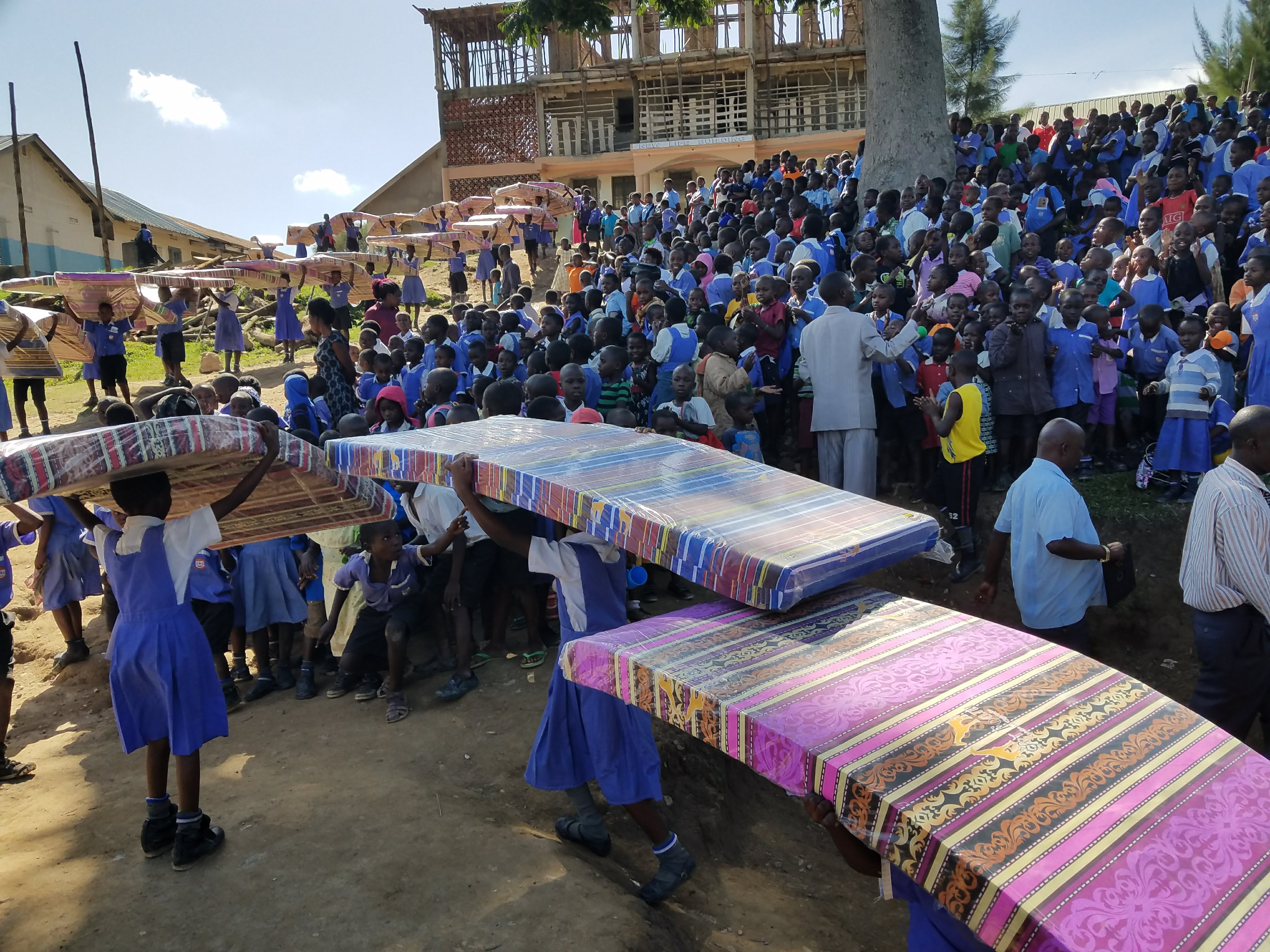 Girls carrying in beds up to orphanage