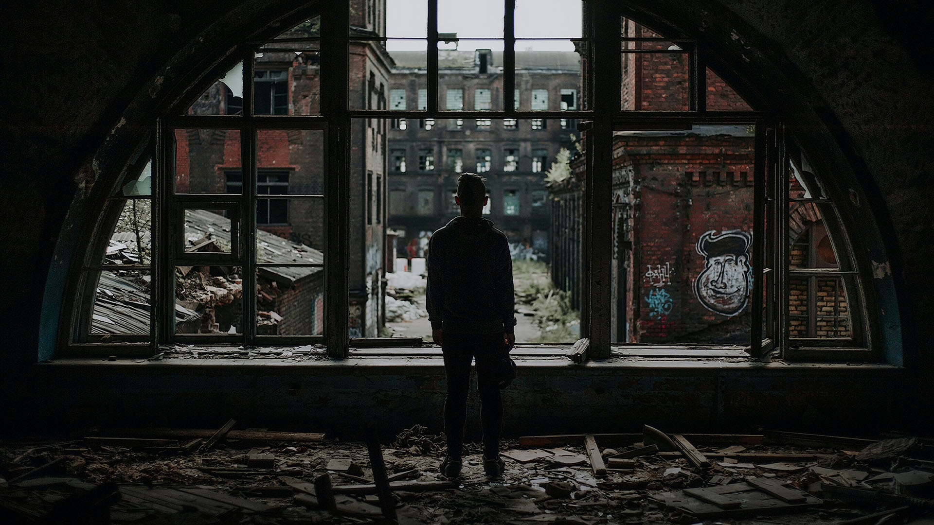 man standing by broken window
