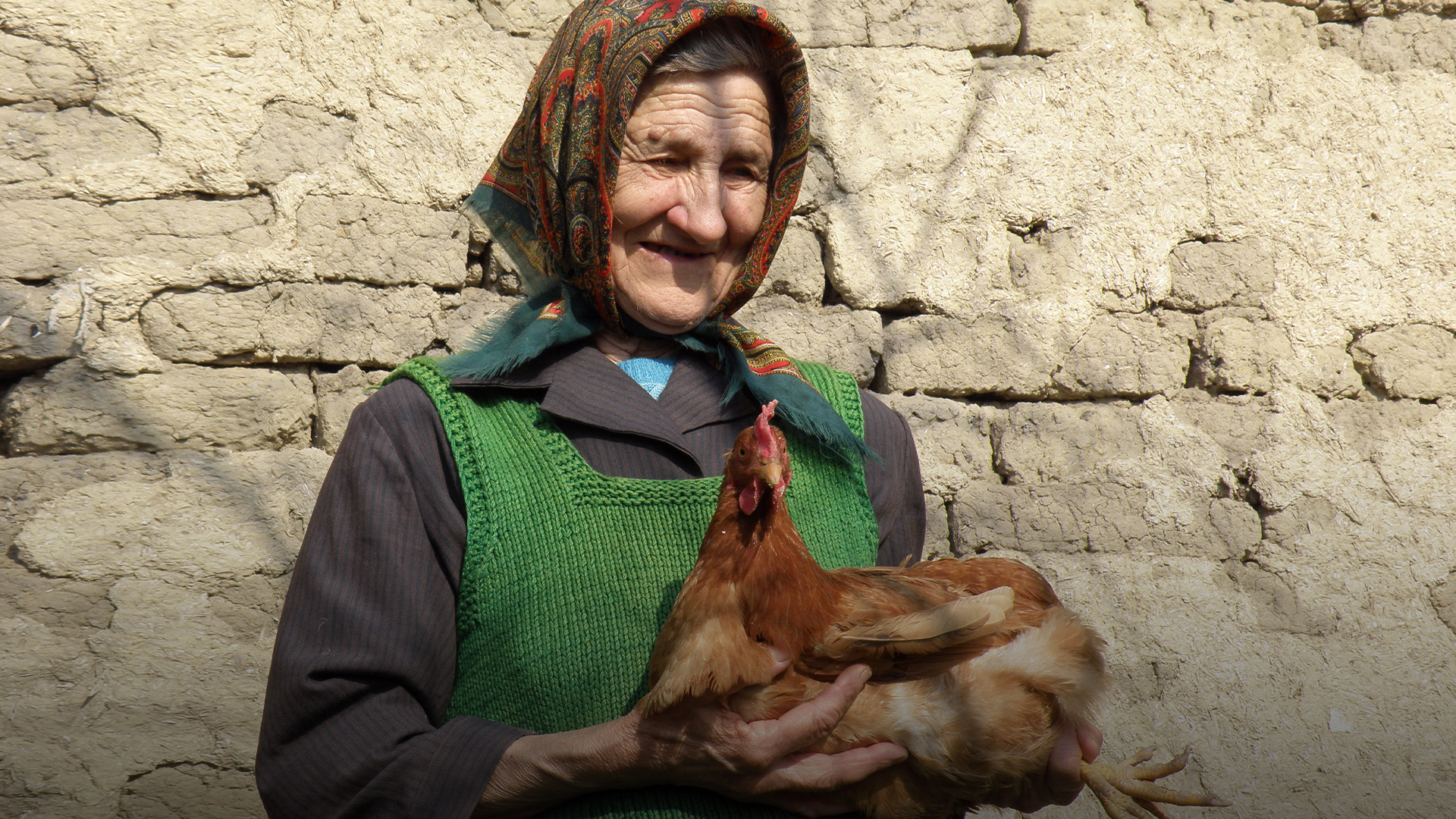 elderly woman holding chicken