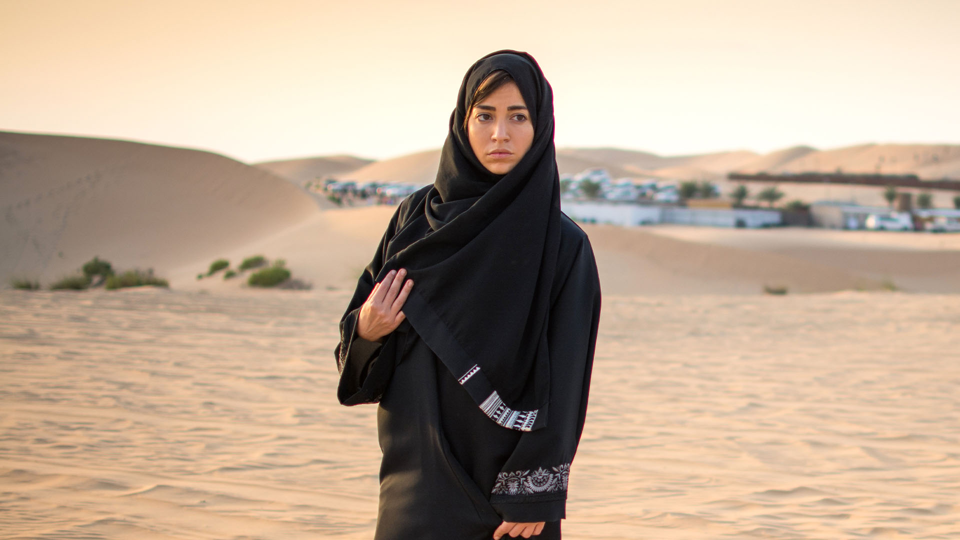 Arab woman walking in a desert