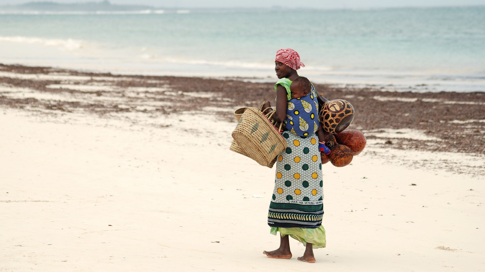 African woman walking along shoreline