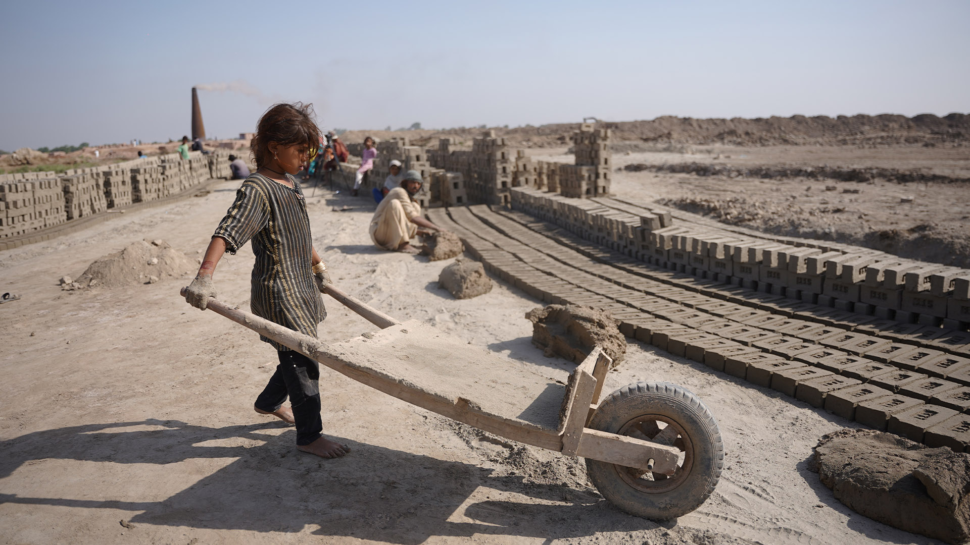 A young girl working alongside her family in the brick kiln.