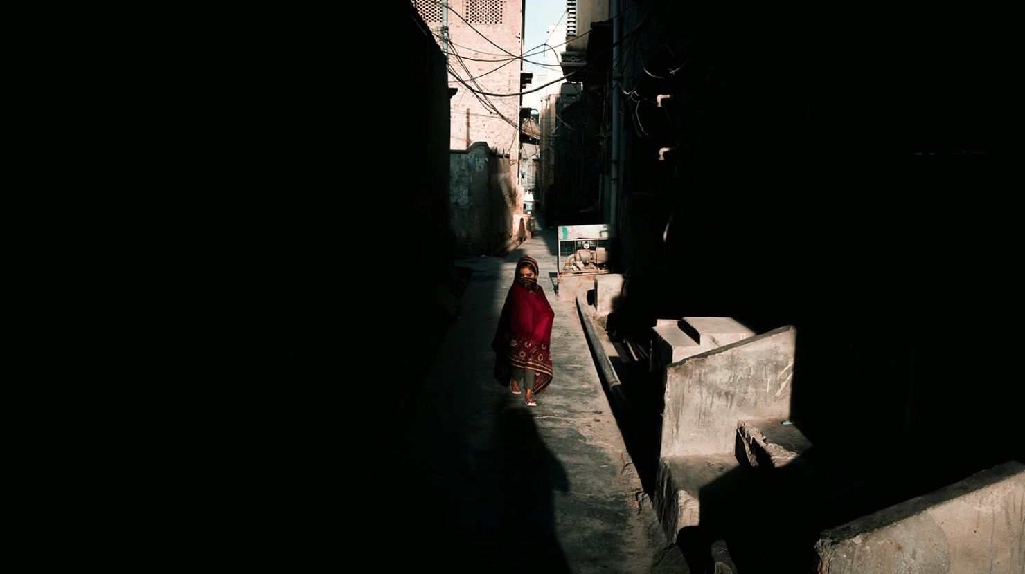 Pakistani child in the shadows between buildings