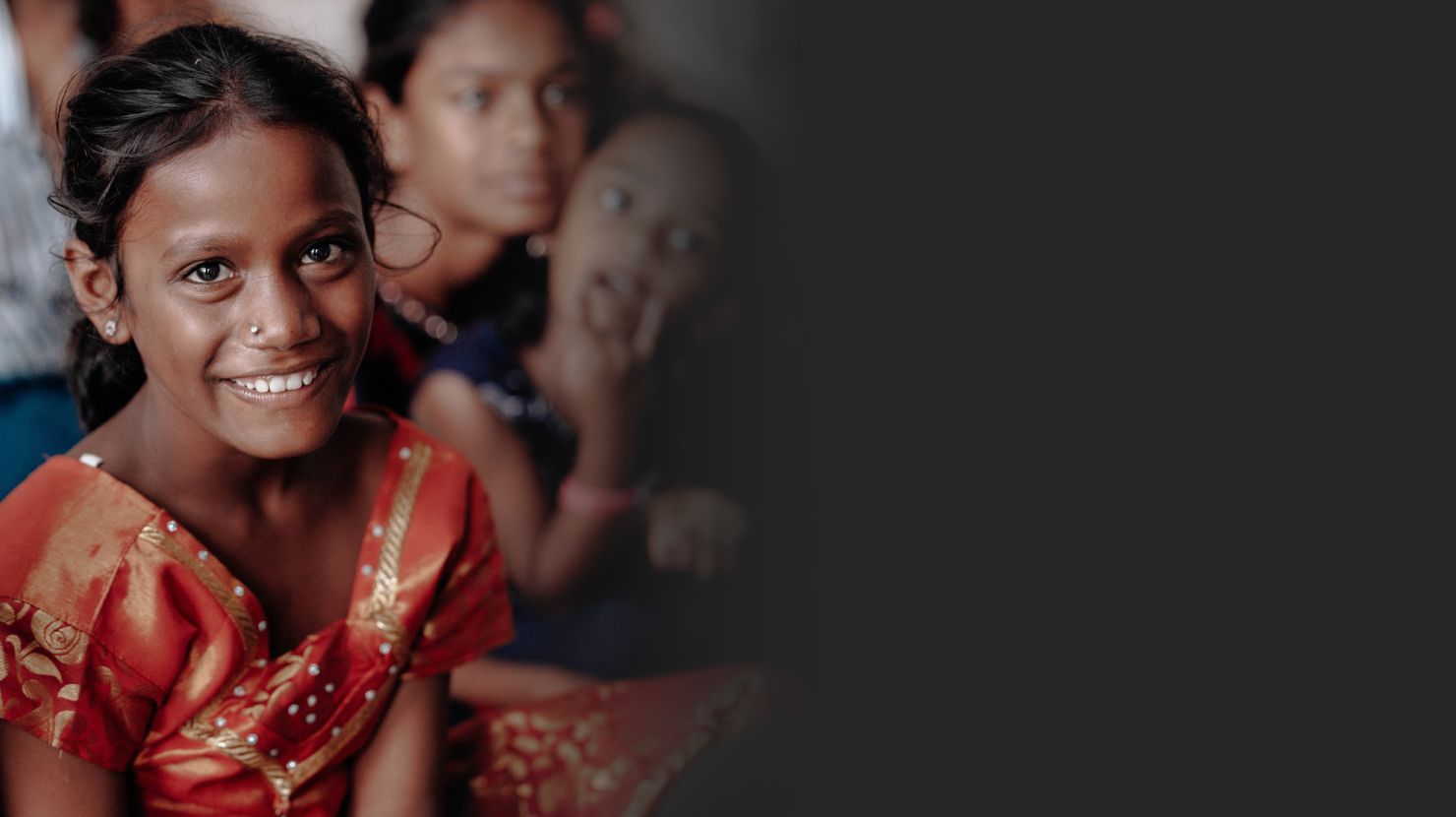 Smiling Indian orphan image faded into gray background