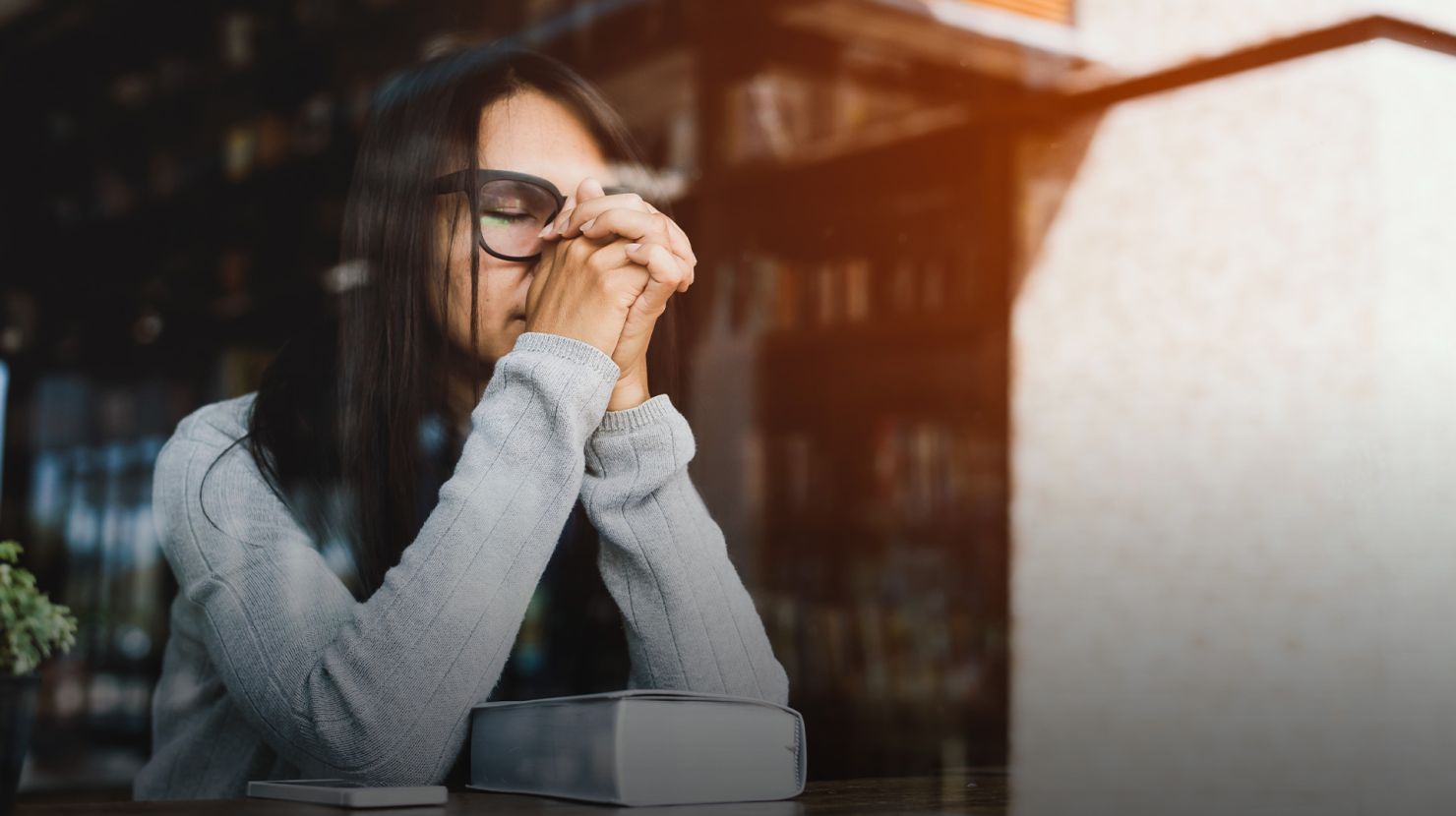 woman praying by a window