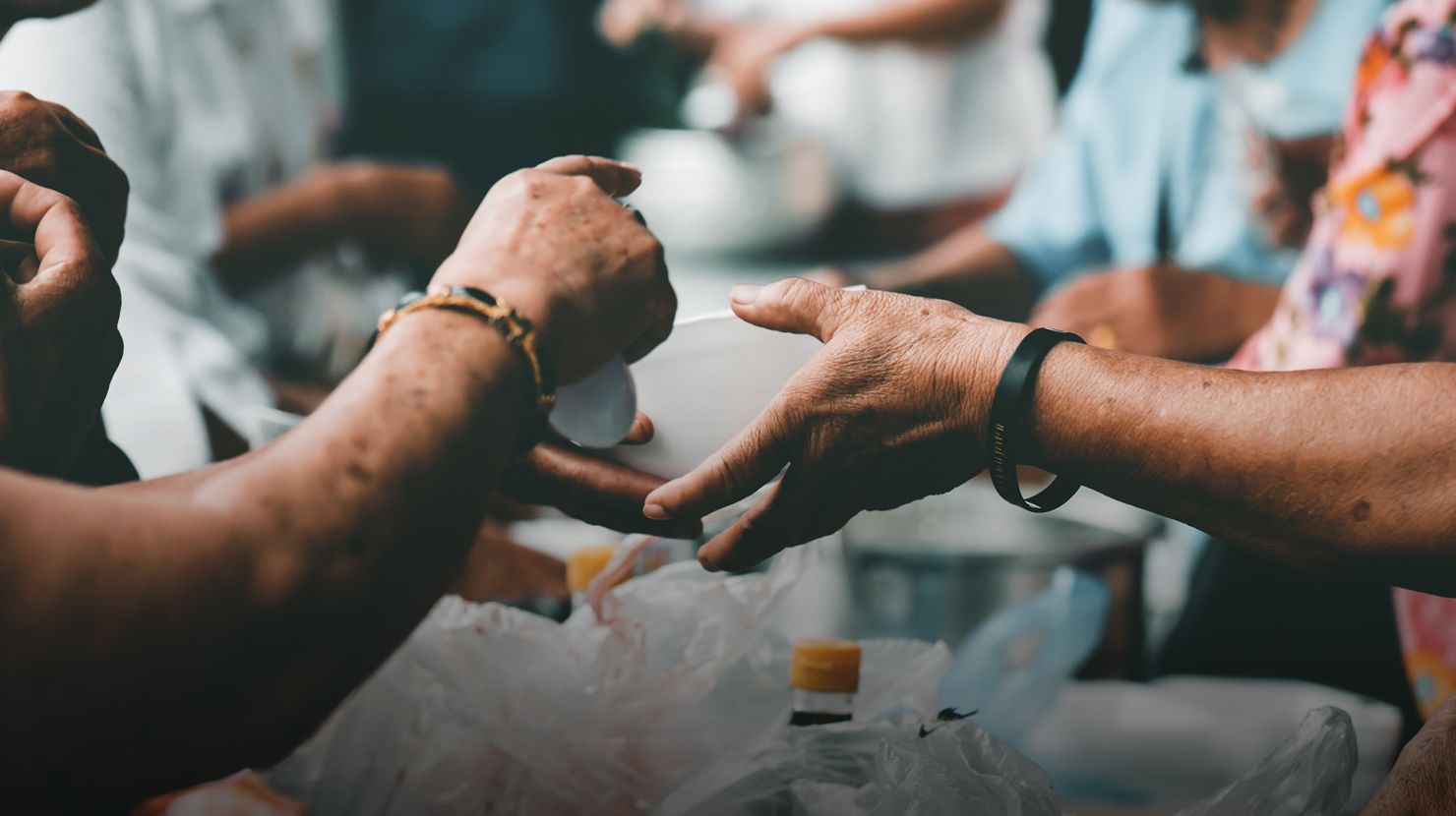 man serving food for another