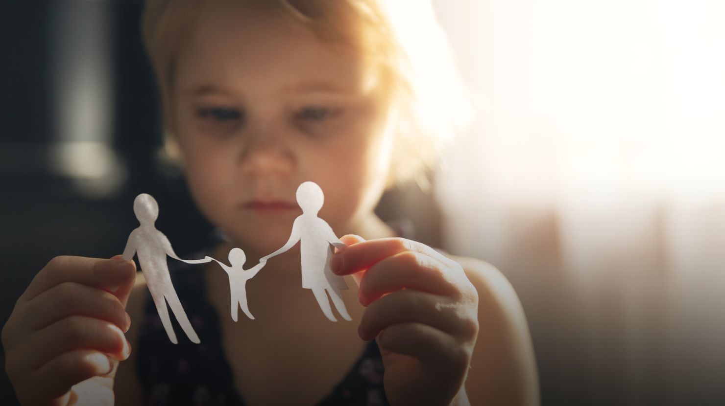 little girl with paper family in hands