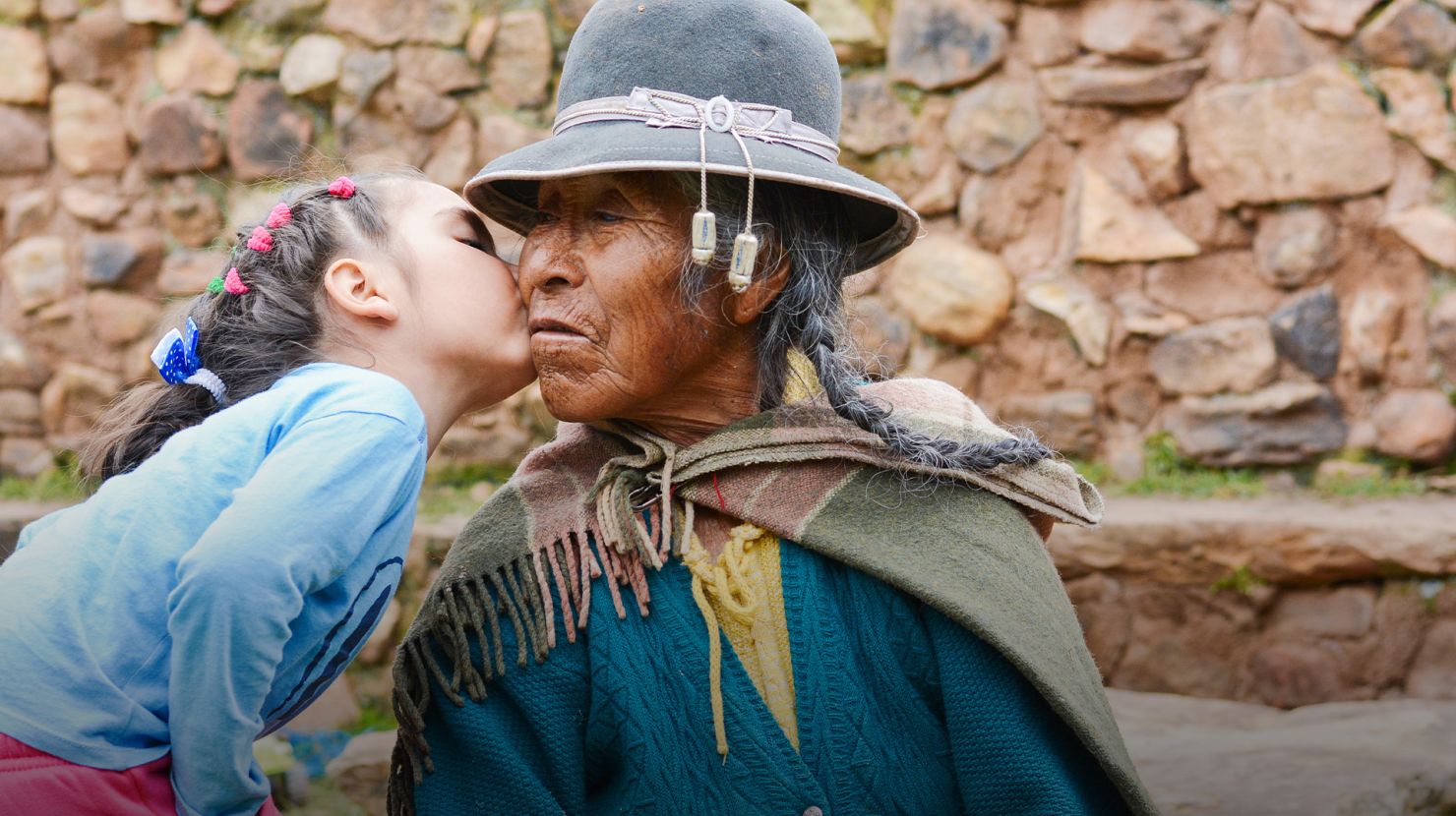 little latin girl kissing her grandmother