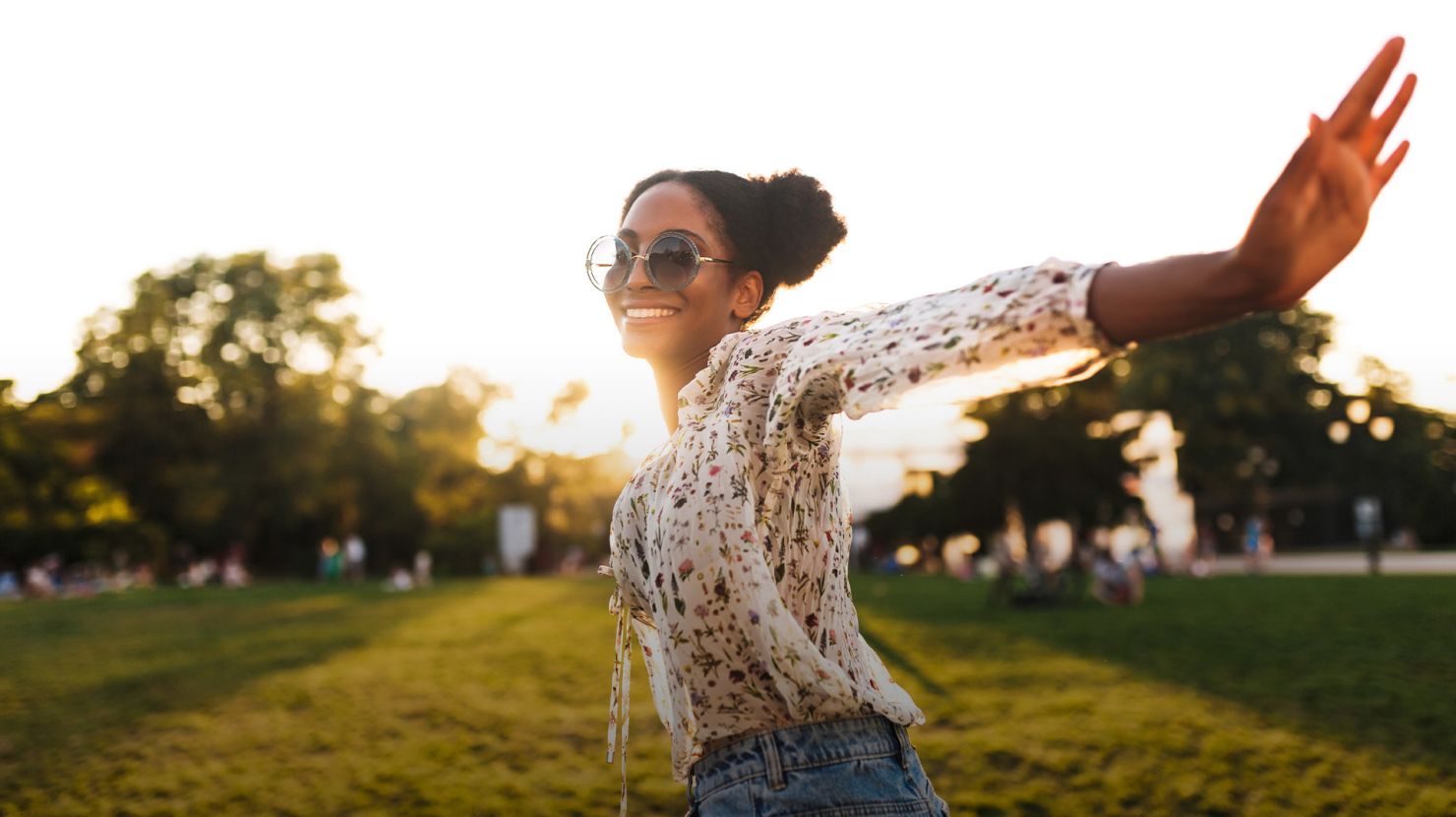 Beautiful smiling african girl in sunglasses joyfully spending time in city park isolated