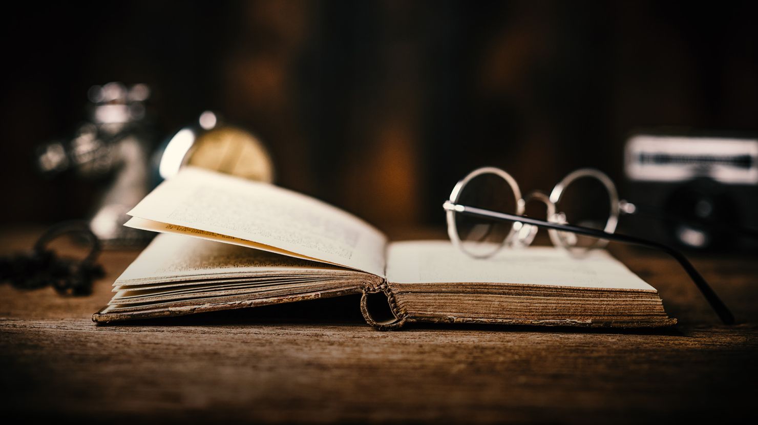 antique book and glasses on a table