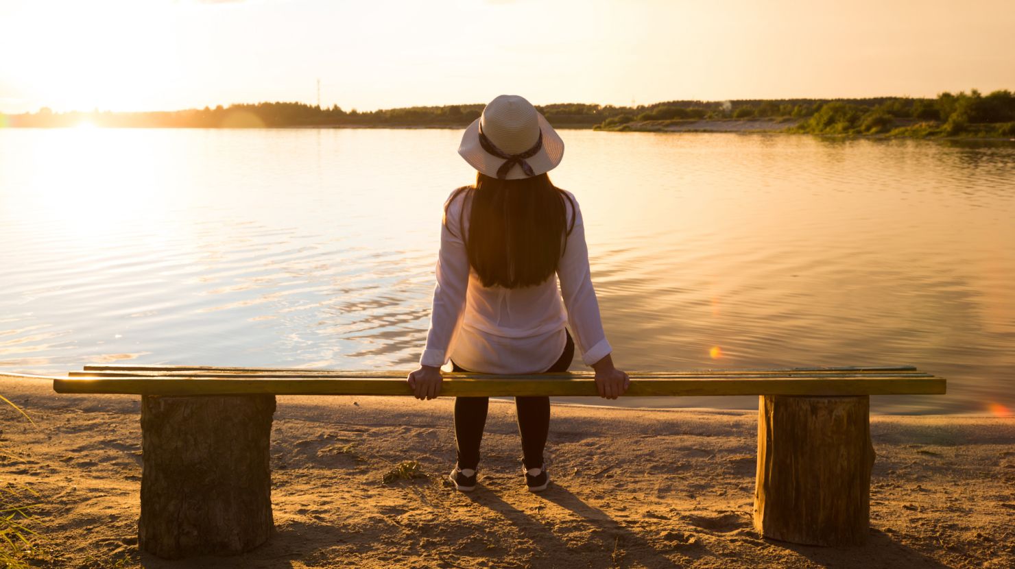 Woman looking out over lake at dusk