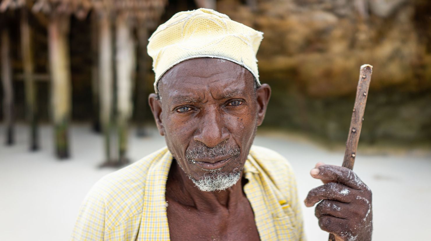 Elderly African man holding stick