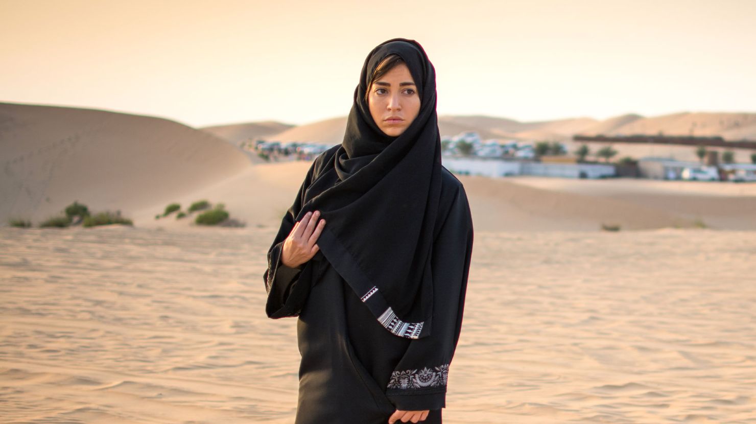 Arab woman walking in a desert
