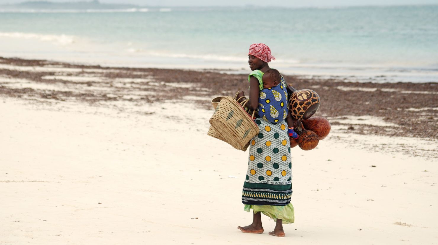 African woman walking along shoreline
