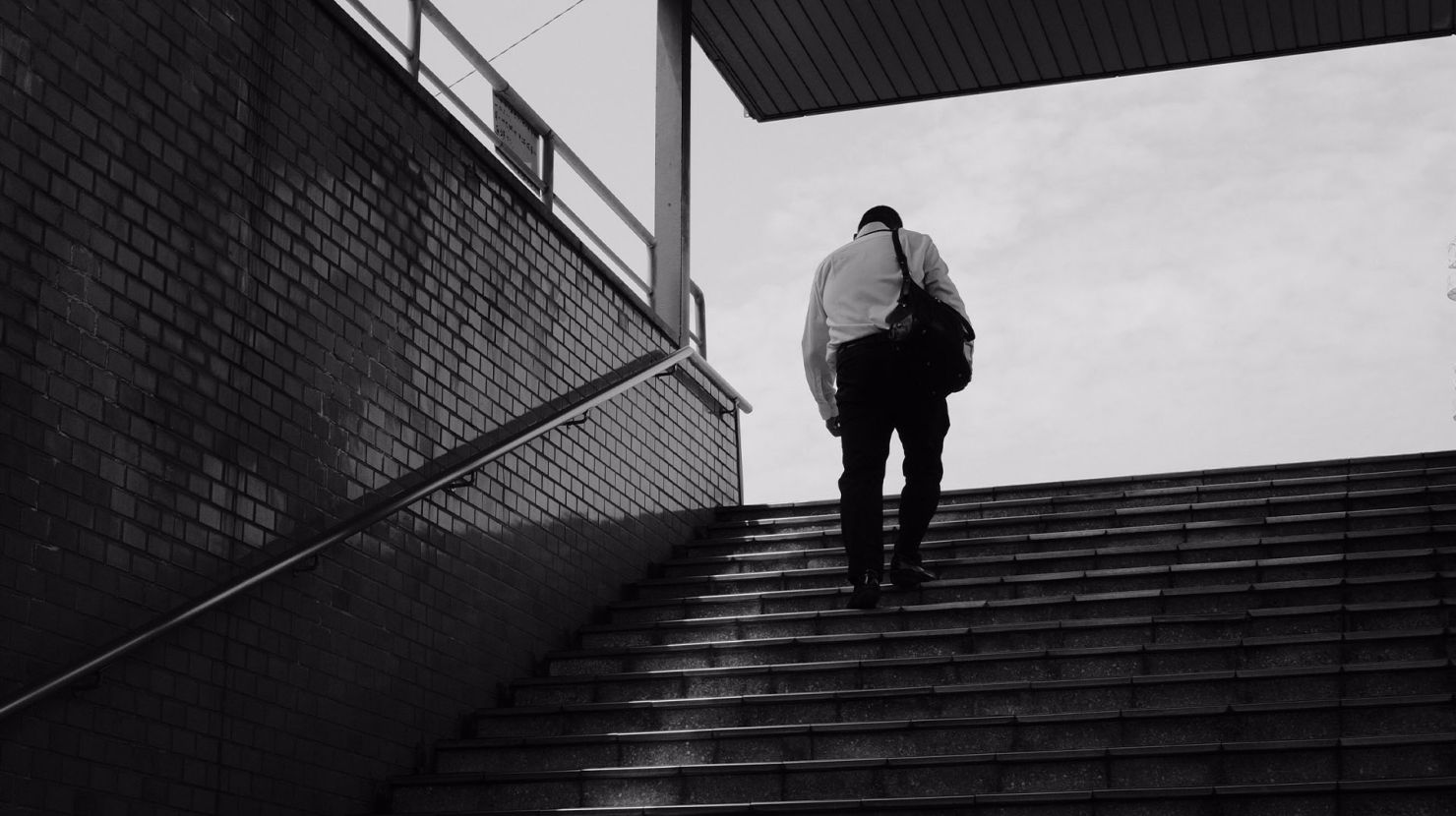 Monochromatic image of man walking up stairs